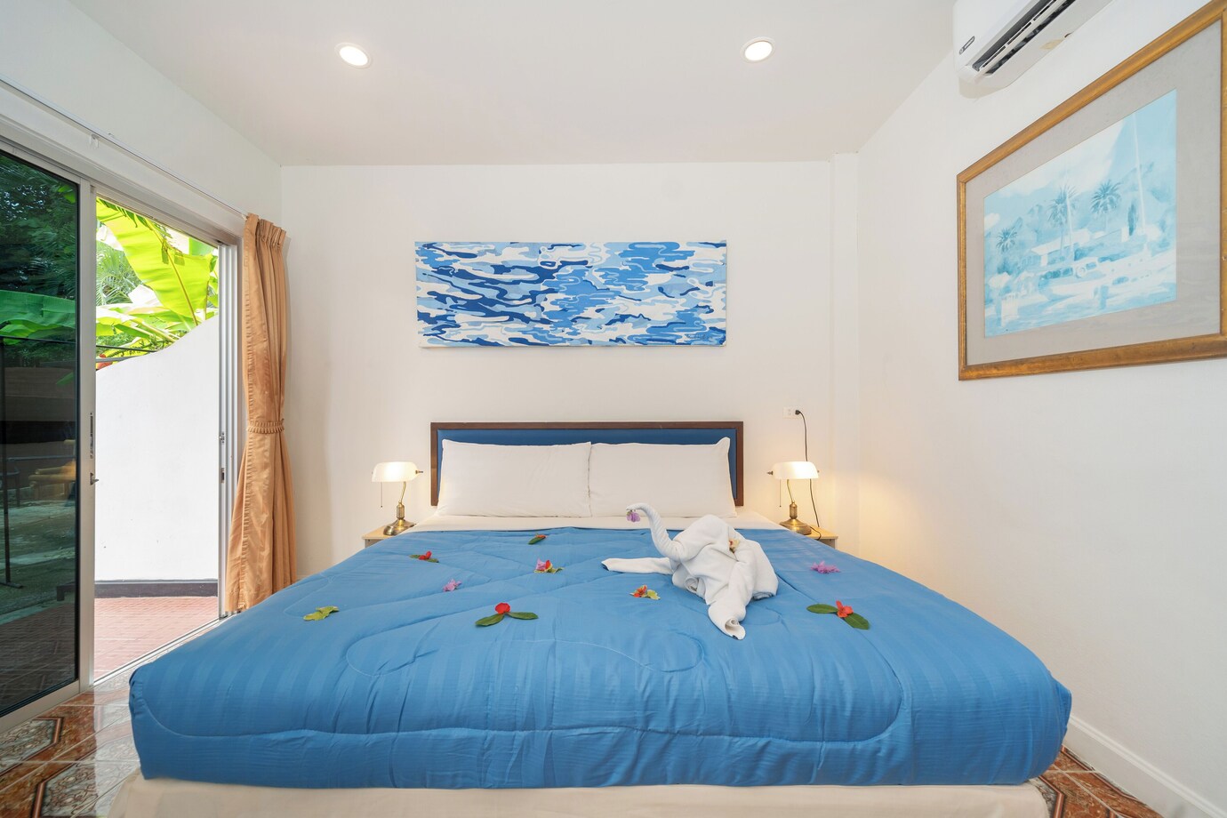 Genuine Oceanview Bungalows guest bedroom with a large blue bed